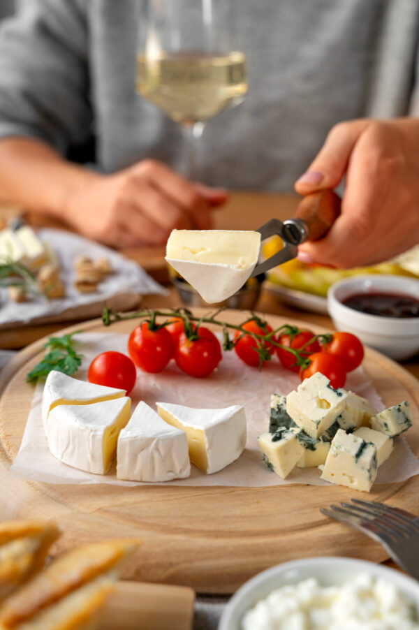 planche de fromage avec femme tenant fromage