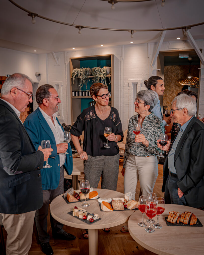 groupe mixte (hommes, femmes, différentes tranches d'âge) réunis autour d'une table de dégustation, dans une ambiance détendue et conviviale. Pas de podium, pas de chrono visible.